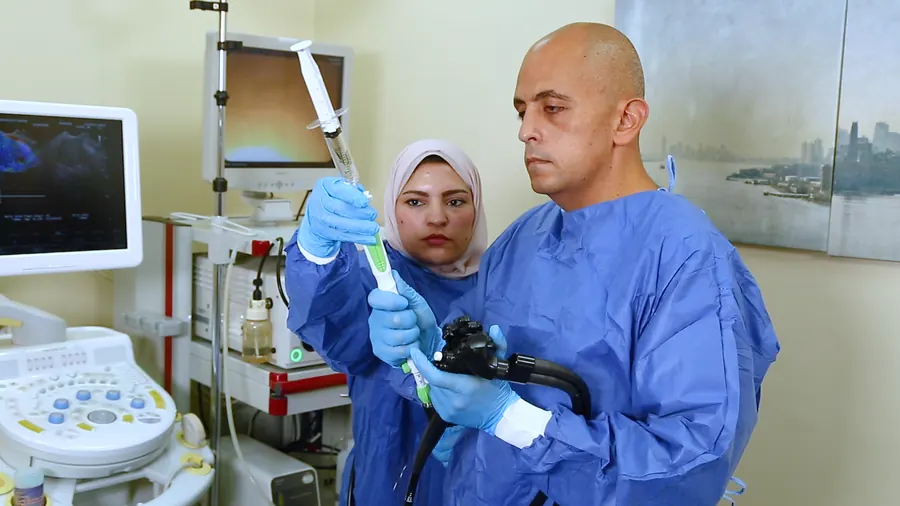 An endoscopist and a nurse prepare an endoscope